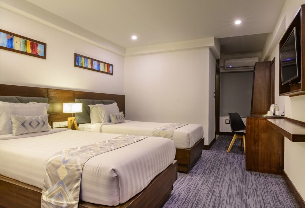 Deluxe room with twin beds, desk and TV at Hotel Zakaria International, Mohakhali, Dhaka