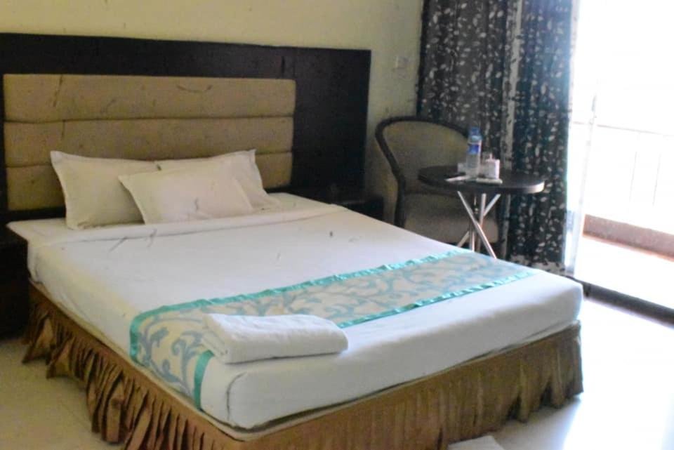 Hotel Coastal Peace guest room with blue-trim bedding