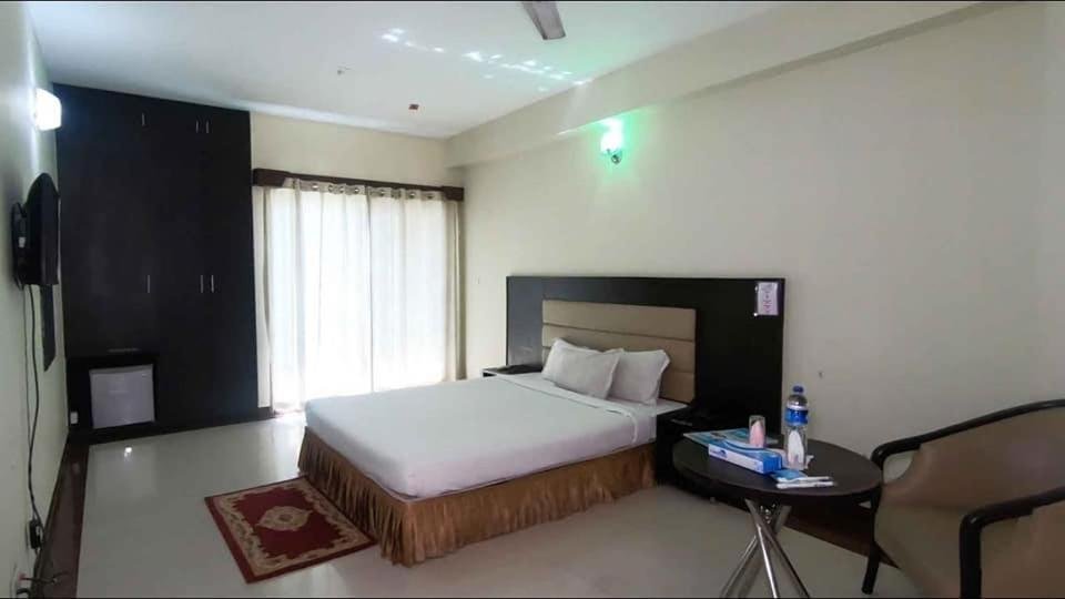 Hotel Coastal Peace room with dark headboard, TV and minibar