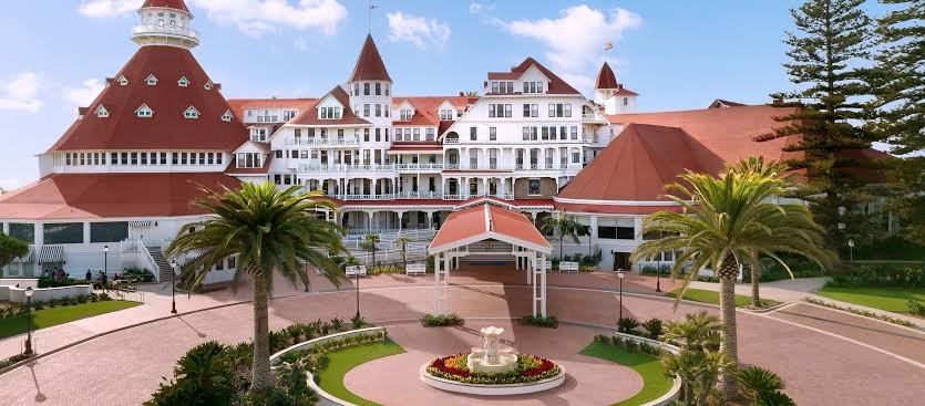 Hotel del Coronado's iconic red-turreted Victorian exterior with palm trees and fountain courtyard