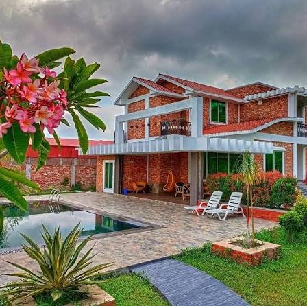Brick cottage with poolside seating and garden at Shaira Garden Hotel & Resorts